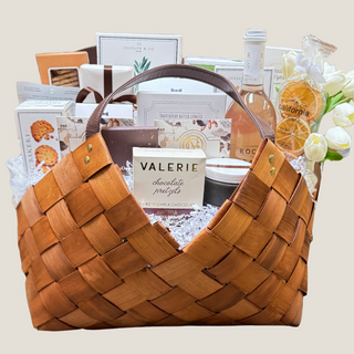This is a photo of a large gift basket named grand epicurean. It is in a light brown woven gift basket with leather handles. It is packed full of delicious food items including gourmet chocolate bars, crackers, crisps, shortbread cookies, sparkling non- alcoholic beverage bottle, premium True Bloom Floral real Touch Flower Garnish, pitted olives, orange crisps, and more! Gift Basket, Gift, Luxury Gift, Luxury Gift Basket, Food Gift, Reno Gift, Biggest Little Baskets, Nevada Gift, Office Gift, Thank you gift