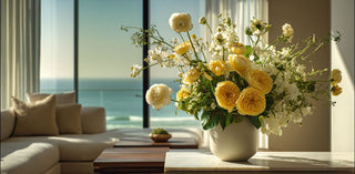 Luxury yellow and white floral arrangement in a ceramic vase styled in a bright coastal living room – elegant decorative florals used in curated gift baskets and premium gifting.