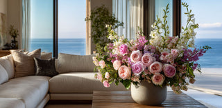 Elegant pink and blush artificial floral arrangement in a ceramic vase styled in a coastal living room – luxury decorative florals used in curated gift baskets and premium gifting.
