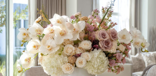 True Bloom Floral real touch faux floral arrangement with white orchids, blush roses, and hydrangeas in an elegant neutral interior