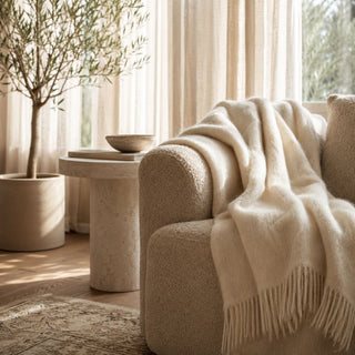 Cozy living room with a textured sofa, a luxury alpaca throw blanket, and decorative elements.