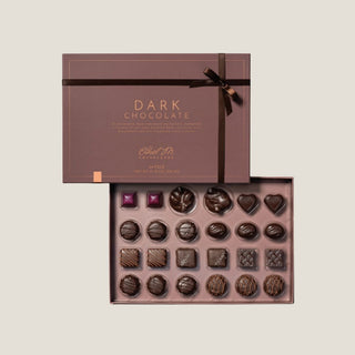 Box of Ethel M dark chocolate truffles with a brown ribbon on a beige background excellent for a luxury gift or holiday present