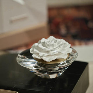 Close view of the Brynn white porcelain flower diffuser set in a clear crystal base for flame-free home fragrance.