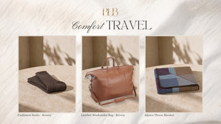 A promotional collage for Comfort Travel by BLB, showing three coordinated travel items: folded brown cashmere socks, a brown leather weekend bag, and a patchwork blue and brown throw blanket, each displayed on a stone surface with warm shadows.
