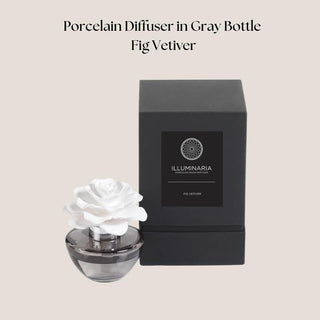 Fig Vetiver porcelain flower diffuser in a gray glass vessel beside its black fragrance presentation box.