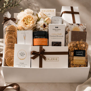  Gathered Grace Gift Box for Luxury Gift Giving with gourmet chocolate truffles, art of caramel gourmet popcorn, nuts, a creamy white bundle of faux florals, a clean scented diffuser gift and an assortment of other gourmet snacks. Perfect gift all gift giving occasions as it can be customized
