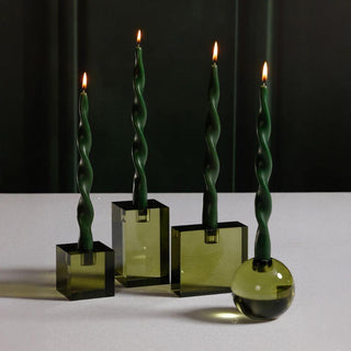 Large square green crystal taper holder displayed with coordinating round and rectangular holders, each holding a lit twisted green taper candle.
