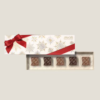 Handcrafted small-batch Ethel M caramels in gold and white snowflake holiday packaging, premium holiday chocolates for corporate and personal gifts Reno Nevada
