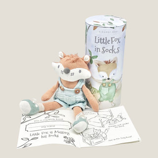 Knit fox toy with illustrated gift cylinder and open black-and-white coloring storybook from the Heirloom Baby Boy gift box.