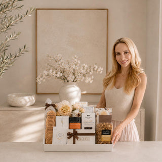 Mel Deakins, owner, at a luxury marble countertop next to the Gathered Grace Gift Box by Biggest Little Baskets