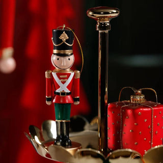 Decorative Nutcracker red and green figurine with black top hat and gold detailing.