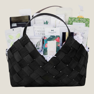 Front product view of the large black woven Office Harmony basket filled with seasonal chocolates, crackers, cookies, tea, nuts, fruit, and savory pantry foods.