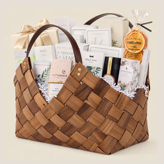 Angled product view of the brown 21-inch Office Harmony woven basket with leather-style handles and a layered seasonal gourmet assortment.