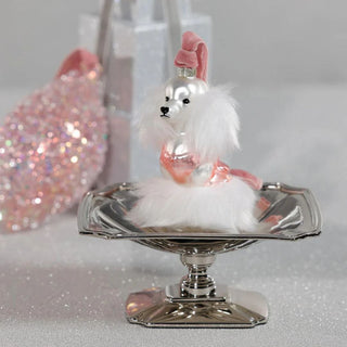 Parisian pup glass ornament with pink and white details resting on a silver pedestal  — elegant holiday décor featuring faux fur accents and reflective metallic ornaments