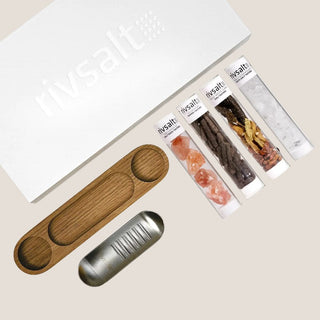 Overhead view of the Rivsalt gift set with a grater, wooden stand, and tubes of salt, long pepper, chilies, and pasta salt.