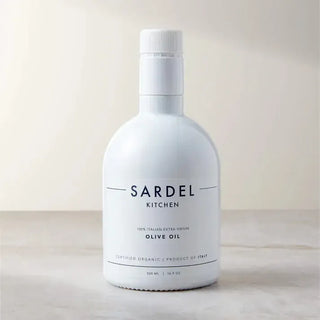 White Sardel Kitchen organic extra virgin olive oil bottle photographed on a pale stone surface.