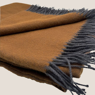 Close-up of bronze-brown baby alpaca fabric and twisted charcoal fringe on the Tapenade throw.
