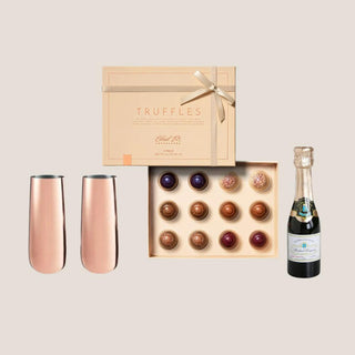 An elegant luxury gift box called the "Turffles & Bubbles The Celebration Box," featuring a candle bottle of sparkling wine, a box of decadent Ethel M. truffles, and two rose-gold champagne flutes. Perfect for weddings, anniversaries, and special occasions, this gourmet gift set highlights the best in Reno's high-end gifting options, Luxury gift box for special occasions, Luxury gift set for anniversaries, celebrations, Premium holiday gift box, Luxury wedding gift set, Corporate gifting idea