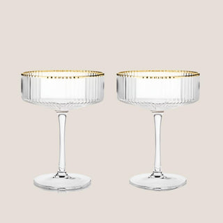 Pair of clear rippled Meridian coupe glasses with fine gold rims and long stems.