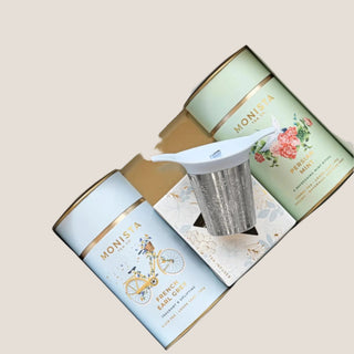 French Earl Grey and Persian Mint loose-leaf tea canisters with a metal stick infuser in an illustrated presentation box.