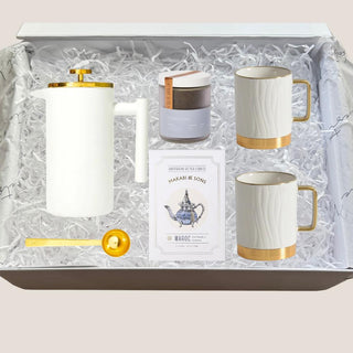 Open white Luxe Tea Indulgence Gift Box arranged with French press, two porcelain mugs, Charles Grey tea, cookies, and gold scoop.
