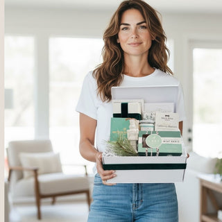 Woman holding the Minted Moments holiday gift box in a bright modern home.