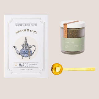 Flat lay of Green Gold loose-leaf tea, rose pistachio cardamom shortbread, and a brushed gold tea scoop.
