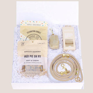 Open white Puppy Love dog gift box with flax leash, waste-bag essentials and gourmet treats nested in white fill.