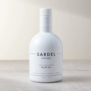 Bottle of Sardel Kitchen olive oil on a light wooden surface with a neutral background