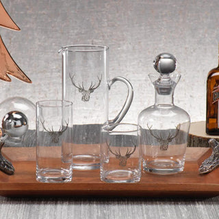 Styled stag-etched glassware collection on a wooden tray; the tumbler listing includes one tumbler only.