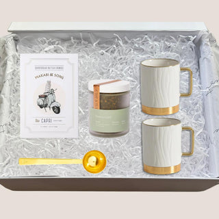 Open Tea Indulgence Gift Box with two white-and-gold mugs, Green Gold tea, shortbread cookies, and gold scoop.