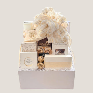 Front view of the Medium Offering gift box with cookies, chocolate, candied almonds, popcorn, gummies, and cream-and-gold bow.