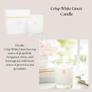 Crisp white linen candle in a clear glass vessel and white presentation box with soft floral styling.