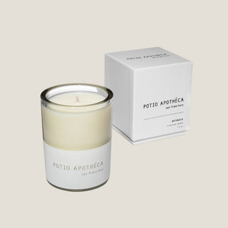 Potio Apotheca Botanica candle in a clear glass jar displayed beside its white box.