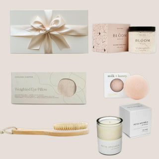 Deluxe spa gift contents arranged together: wild rose bath soak, body brush, konjac sponge, eye pillow and botanical candle.