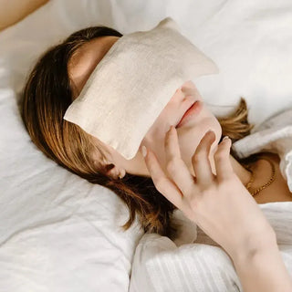 Woman resting with a lavender aromatherapy weighted eye pillow placed across her eyes.