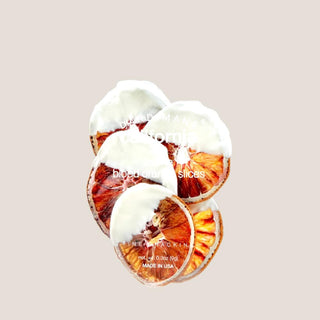 Dried blood orange slices finished with white chocolate and displayed in clear packaging.