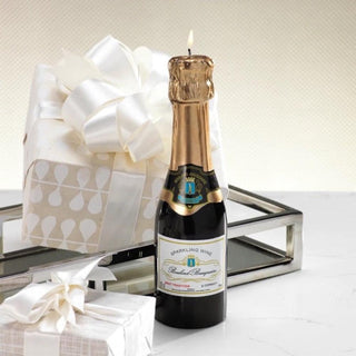 Mini champagne bottle-shaped wax candle with label detail, measuring 2 inches wide by 7.75 inches high.