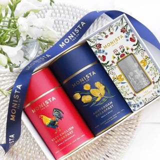 Very English Breakfast and Amsterdam Breakfast tea canisters with a boxed metal infuser and navy Monista ribbon.