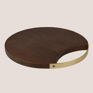 Round dark mango wood serving and cutting board with a curved gold-tone handle accent.
